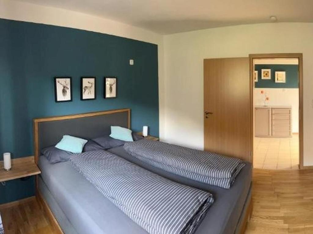1 cama grande en un dormitorio con una pared azul en Ferienwohnung Lydia, en Zell am Harmersbach