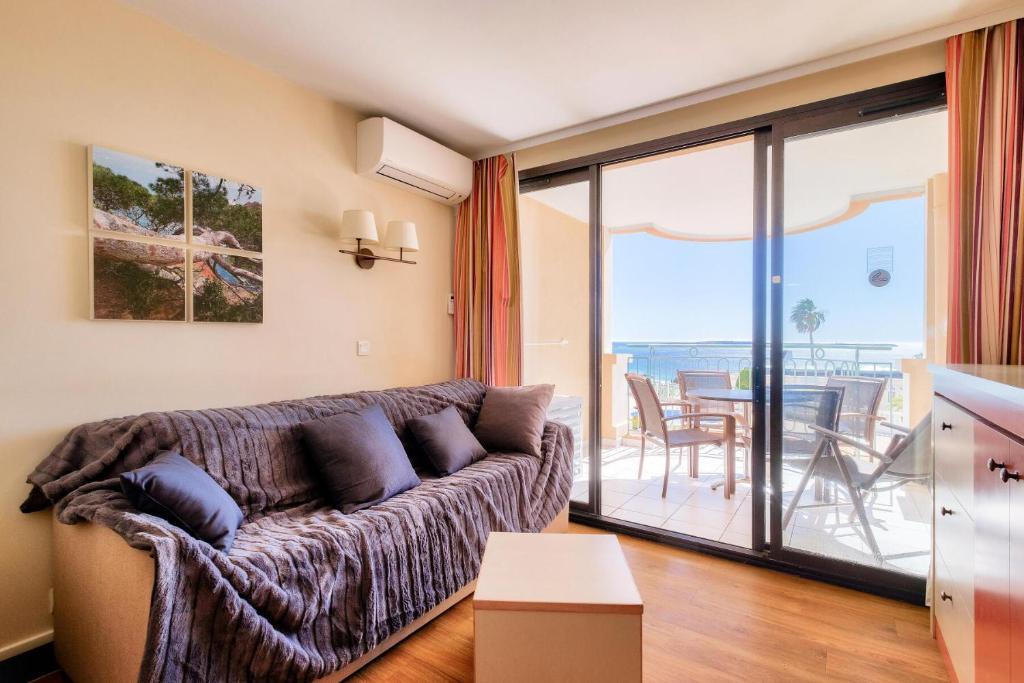 d'un salon avec un canapé et un balcon. dans l'établissement Résidence Cannes Villa Francia - maeva Home - Appartement 2 pièces 4 personnes - Sélection MAE-2351, à Cannes
