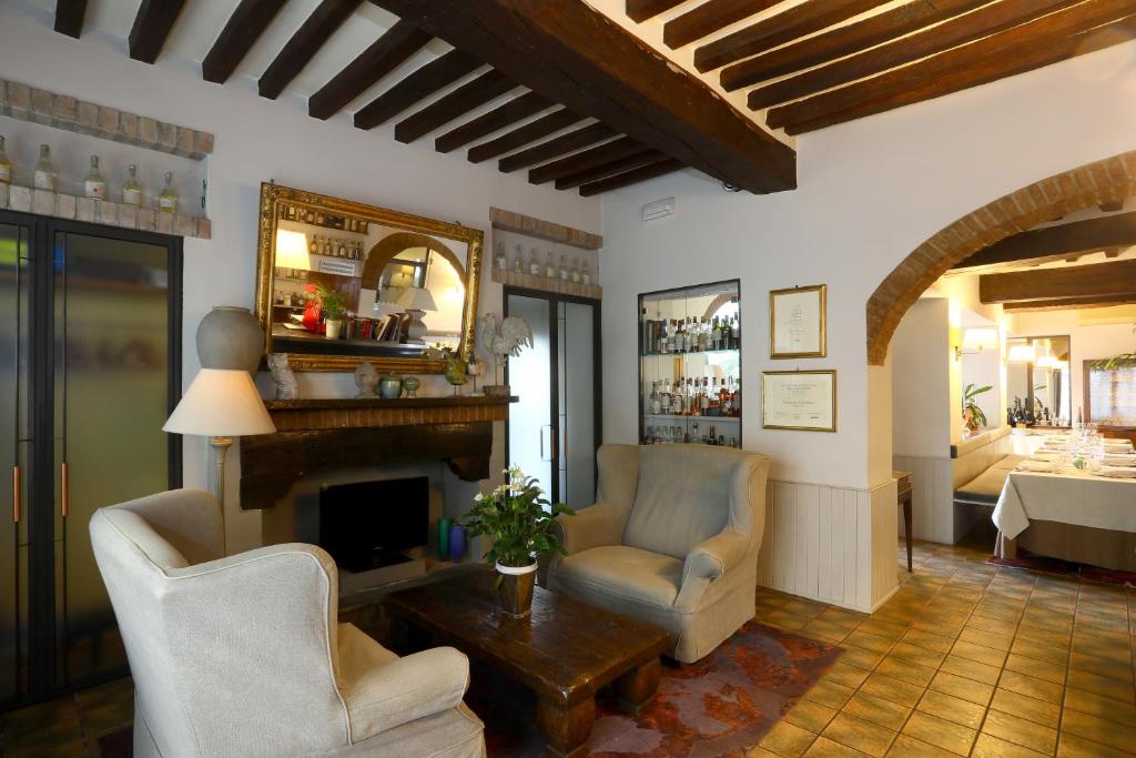 Locanda Stella d'oro في Soragna: غرفة معيشة مع كرسيين ومدفأة