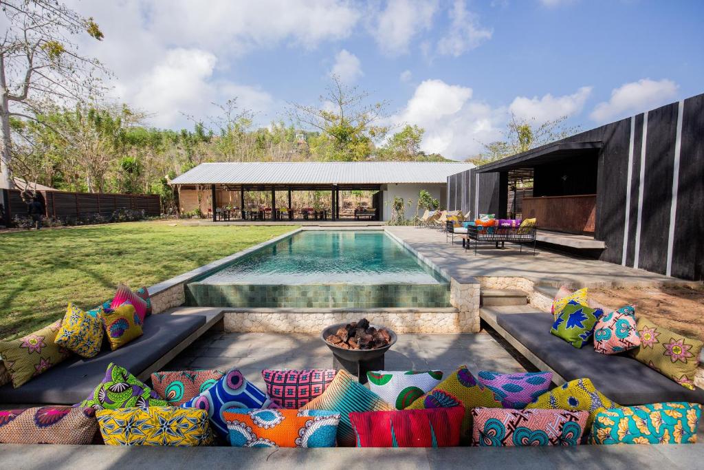ein Haus mit Pool und vielen Kissen in der Unterkunft Origin Uluwatu in Uluwatu