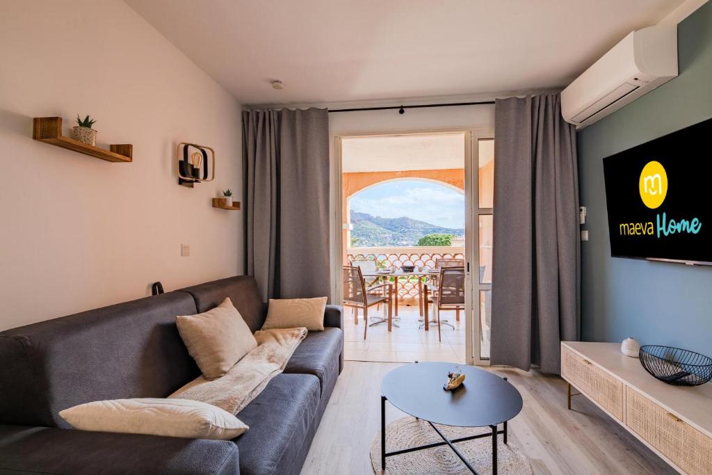 un salon avec un canapé et une table dans l'établissement Résidence le Village de Cap Esterel - maeva Home - Appartement cosy 2 pièces 4 personnes - Prestige - super Home MAE-2121, à Saint-Raphaël