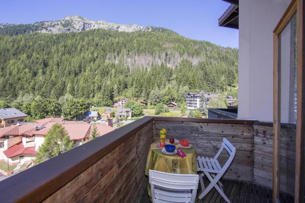 d'une table et de chaises sur un balcon avec vue sur la montagne. dans l'établissement Résidence Grand Roc - Campanules 403 - Happy Rentals, à Chamonix-Mont-Blanc