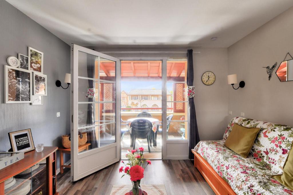 un salon avec un canapé et une table dans l'établissement La résidence du Lac - maeva Home - Appartement cosy avec balcon 2 pièces 4 personnes - Prestige - super Home MAE-6751, à Monflanquin