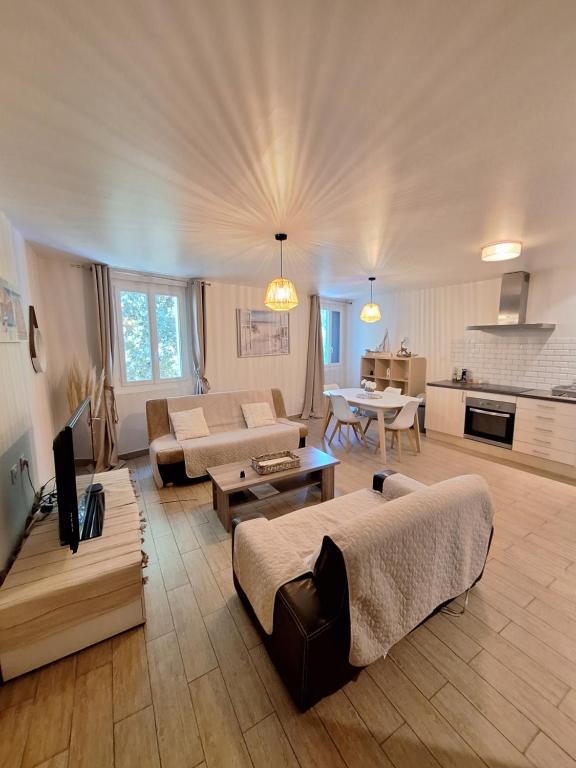 un salon avec un canapé et une table dans l'établissement Charmant Appartement paisible à 5 mn en voiture de la plage, à Canet