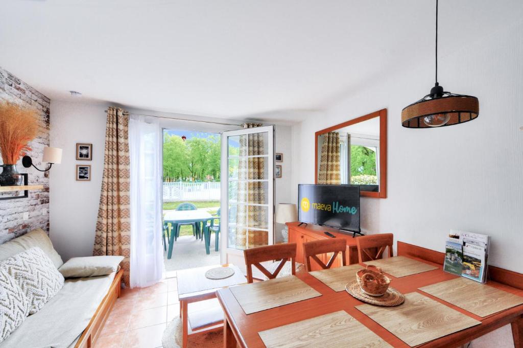 un salon avec une table et un canapé dans l'établissement La résidence du Lac - maeva Home - Maison 3 pièces 6 personnes - Prestige MAE-0191, à Monflanquin