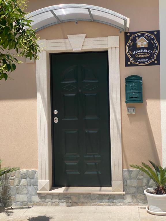 eine schwarze Vordertür eines Hauses mit einem Schild in der Unterkunft Appartamento da Antonio in Parghelia
