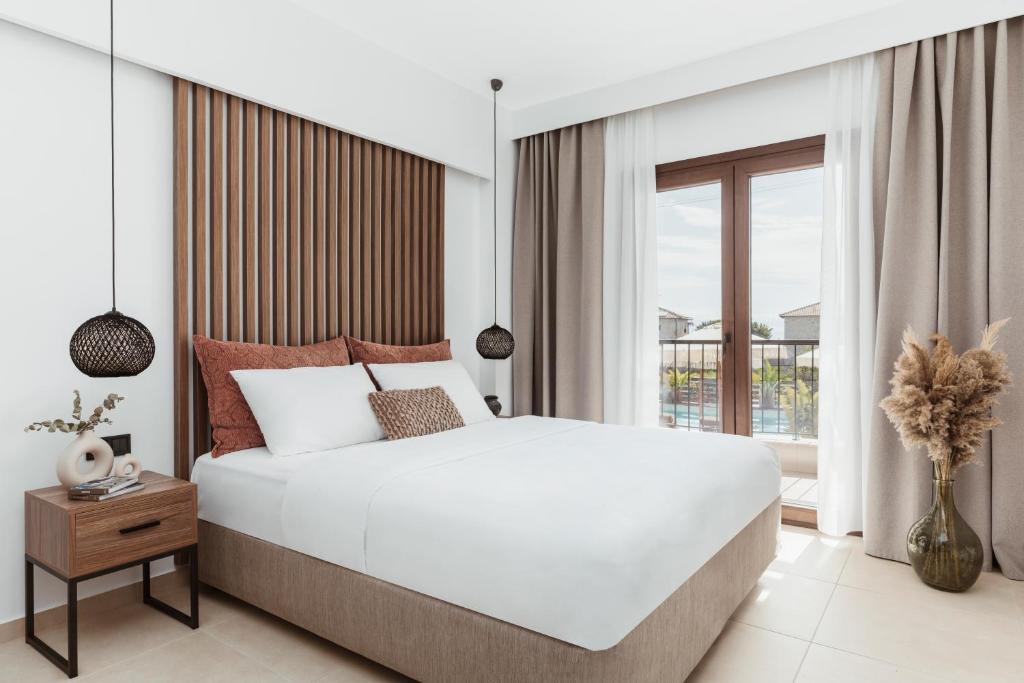阿菲托斯的住宿－Verano Afytos Hotel，一间卧室设有一张大床和一个窗户。