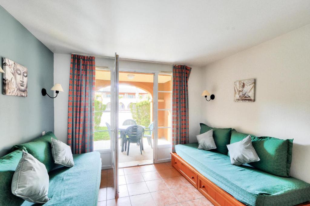 d'un salon avec un canapé et un balcon. dans l'établissement La résidence du Lac - maeva Home - Studio 5 personnes - Sélection MAE-0051, à Monflanquin
