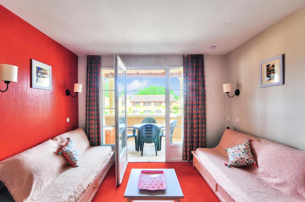 un salon avec deux canapés et une table dans l'établissement La résidence du Lac - maeva Home - Appartement 2 pièces 5 personnes - Sélection MAE-0211, à Monflanquin