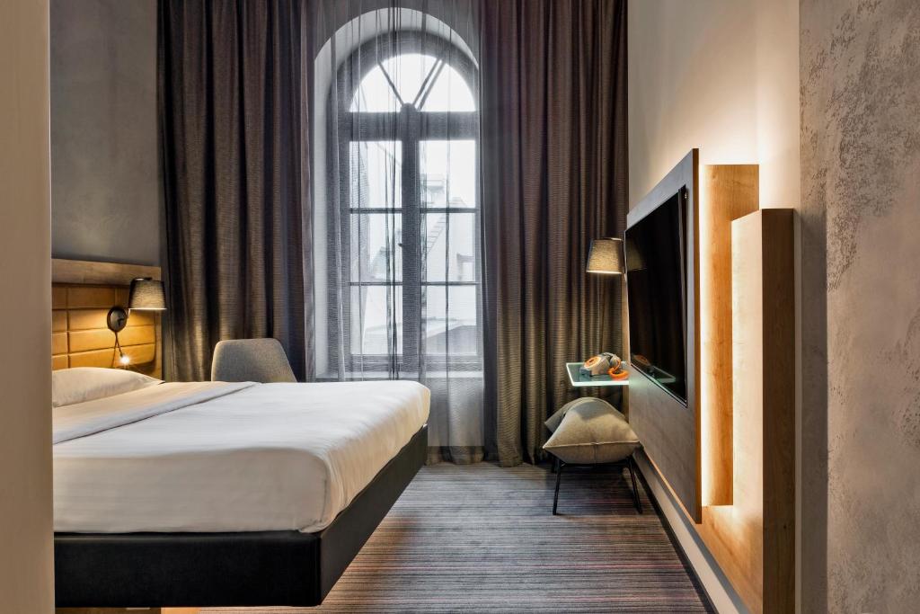 a hotel room with a bed and a window at Moxy Warsaw Praga in Warsaw