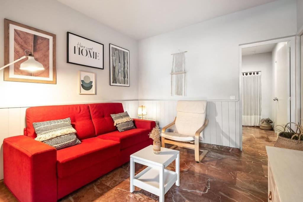 バルセロナにあるPark Guell Gaudi 2 bedroom Apartmentのリビングルーム(赤いソファ、椅子付)
