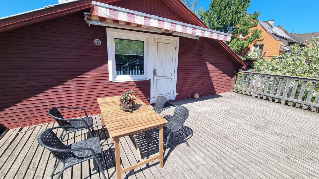 a wooden table and chairs on a wooden deck at Tihase one bedroom garden view apartment in Tallinn