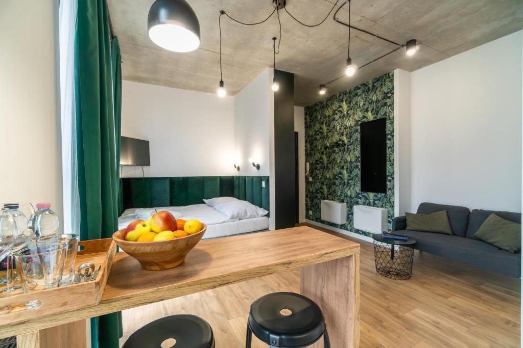 a living room with a bowl of fruit on a table at Apartamenty Silver Place in Szczecin