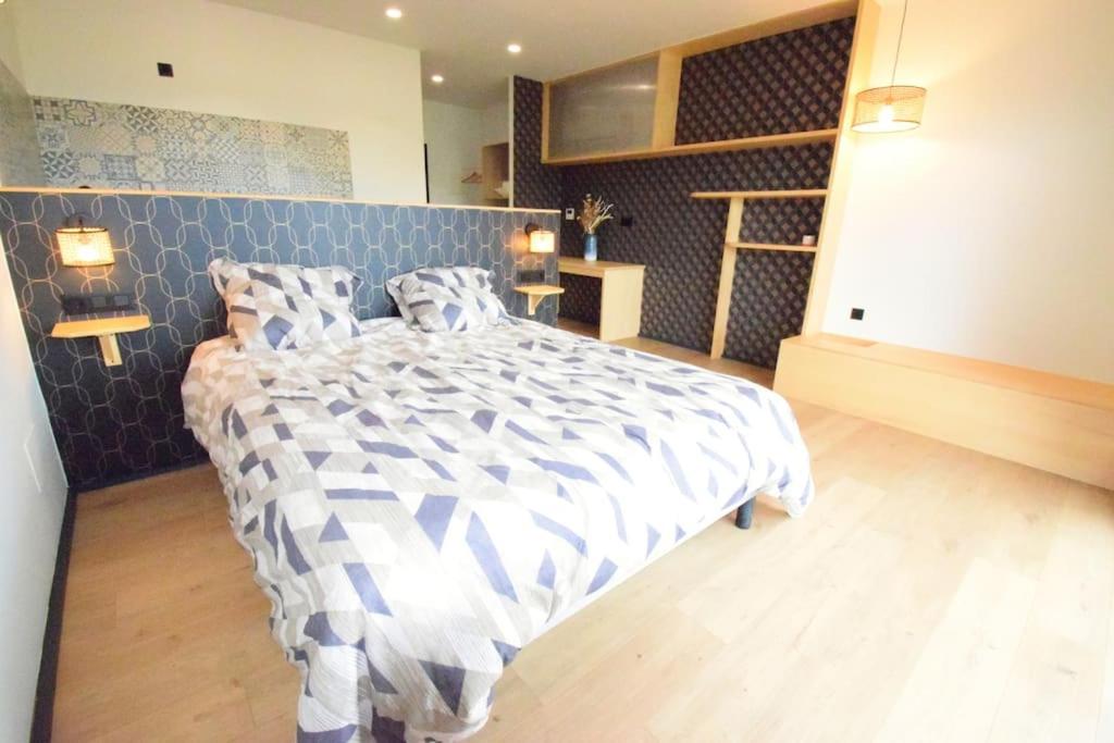 a bedroom with a bed with a blue and white comforter at Appartement vue montagnes- IBANTELI in Zugarramurdi