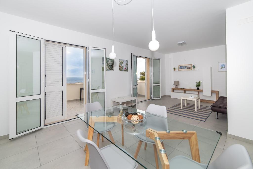 a living room with a glass table and chairs at Una prua sul mare in Nardò