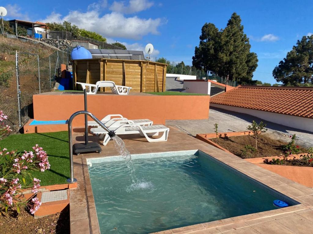 una piscina con una fuente en una casa en helios casa vacacional, en Puntagorda