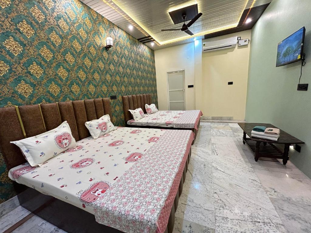 a room with two beds and a table at TEMPLE TOWN HOMES assi ghat Varanasi in Varanasi