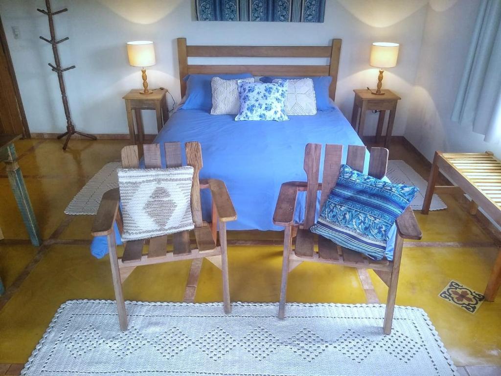 a bedroom with a bed and two chairs and a table at Pousada Pedra Grande in Bueno Brandão