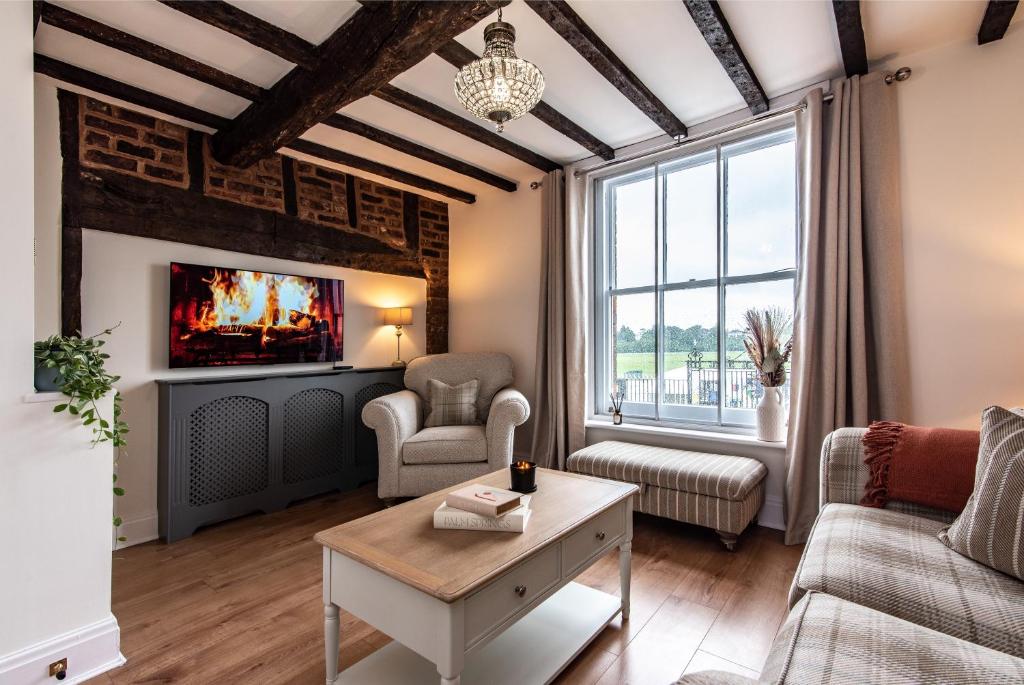 a living room with a fireplace and a tv at Luxury Chester Townhouse with Parking in Chester