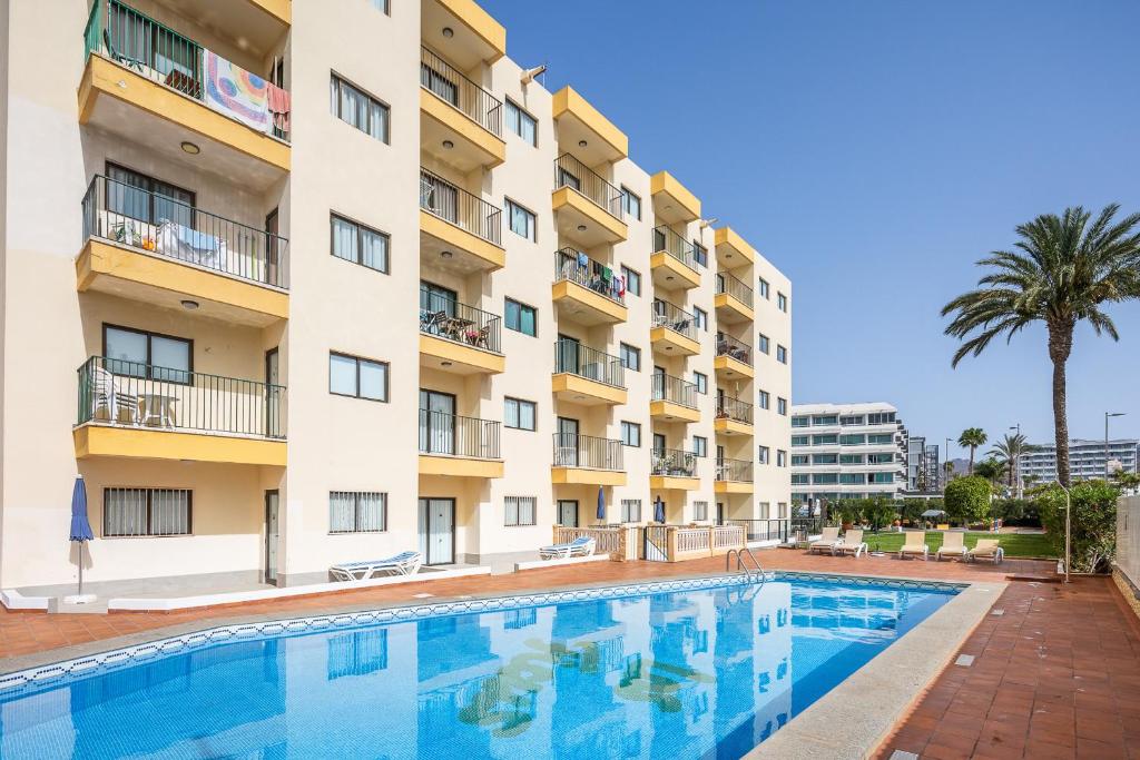 a swimming pool in front of a building at Los Ficus in Playa del Ingles