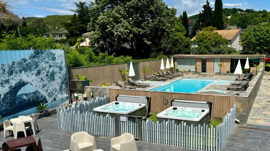 a swimming pool with two chairs and a fence at Logis Hôtel Restaurant Bellevue in Saint-Martin-dʼArdèche
