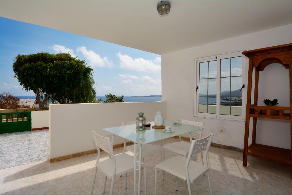 un comedor blanco con mesa de cristal y sillas en Apartment Lapa Punta Mujeres Sea Views By PVL, en Punta Mujeres