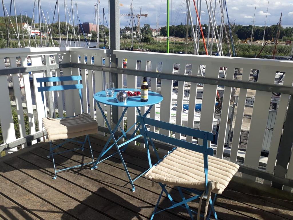 グライフスヴァルトにあるFeWo Liegeplatz am Yachthafenのバルコニー(ボート付)にテーブルと椅子2脚