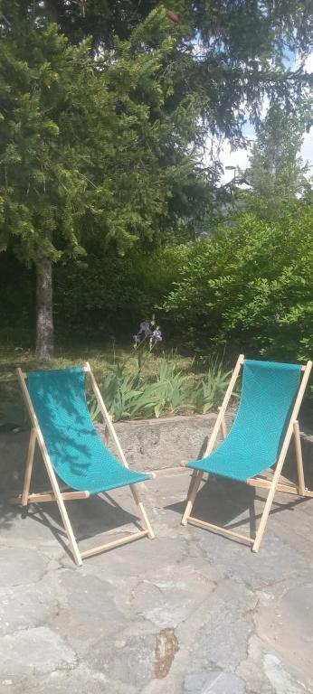 Dos sillas azules sentadas en un patio en Charmant T2 spacieux au pied de Montdauphin, en Eygliers