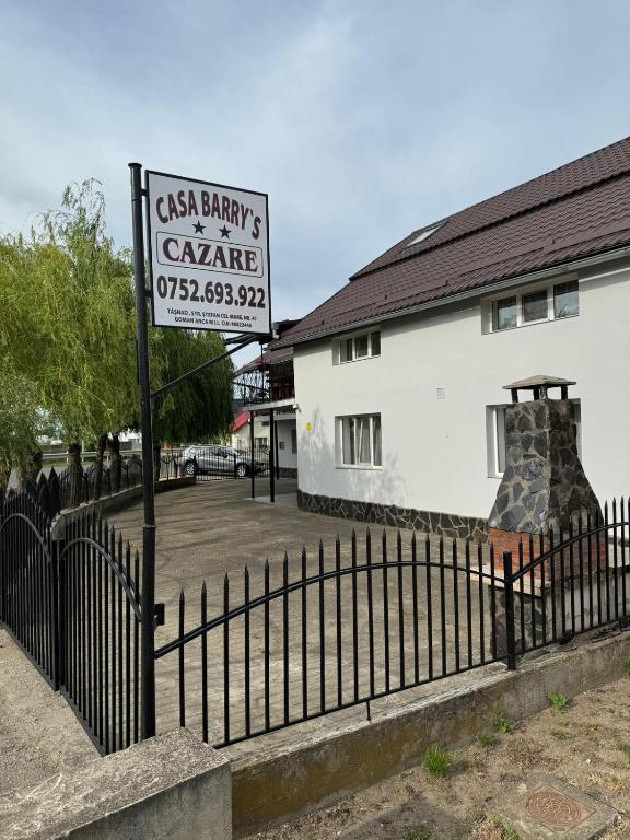 a sign on a fence in front of a building at Casa Barry's in Tăşnad