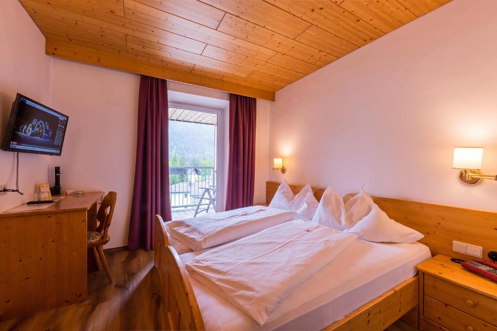 Postel nebo postele na pokoji v ubytování Hotel Dolomiten