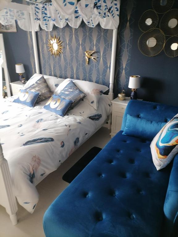 une chambre avec un lit et une chaise bleue dans l'établissement Chez Fabiola et Alain, à Signy-le-Petit