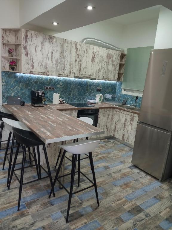 a kitchen with a wooden table and a refrigerator at Διαμέρισμα δίπλα στο InterContinental! in Athens