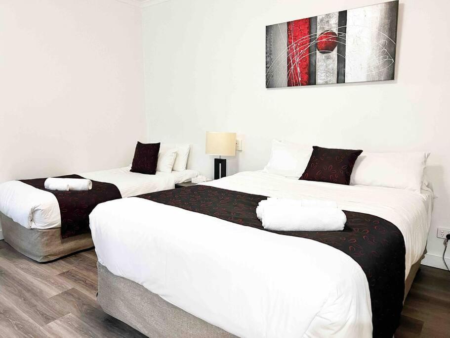two beds in a room with white walls at 259 Gouger city unit 105 in Adelaide