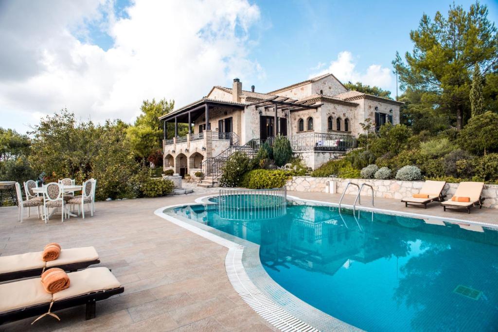 un domaine avec une piscine en face d'une maison dans l'établissement Alexandros Stone Villa, à Ágios Nikólaos