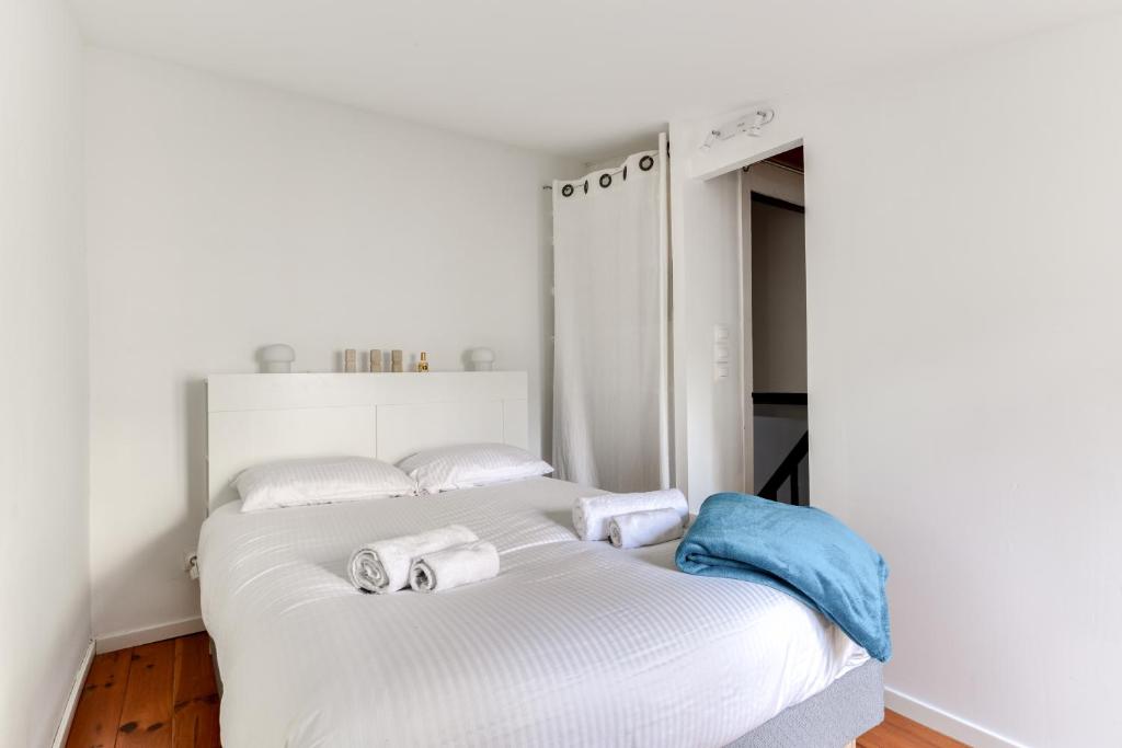 une chambre avec deux lits avec des serviettes dessus dans l'établissement Le Patio de la Bastide avec Terrasse & Netflix - Quartier paisible, à Carcassonne