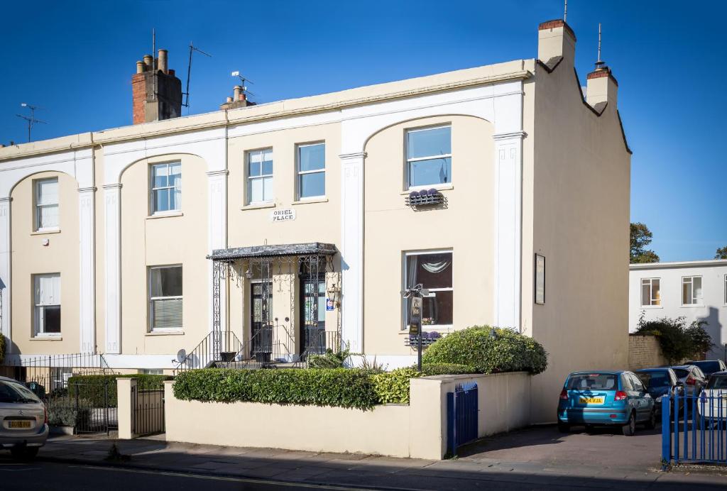 a white house with cars parked in front of it at Crossways Guest House in Cheltenham