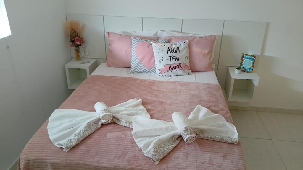 a bed with two bows on top of it at Lofts Primavera Centro Histórico Paraty in Paraty