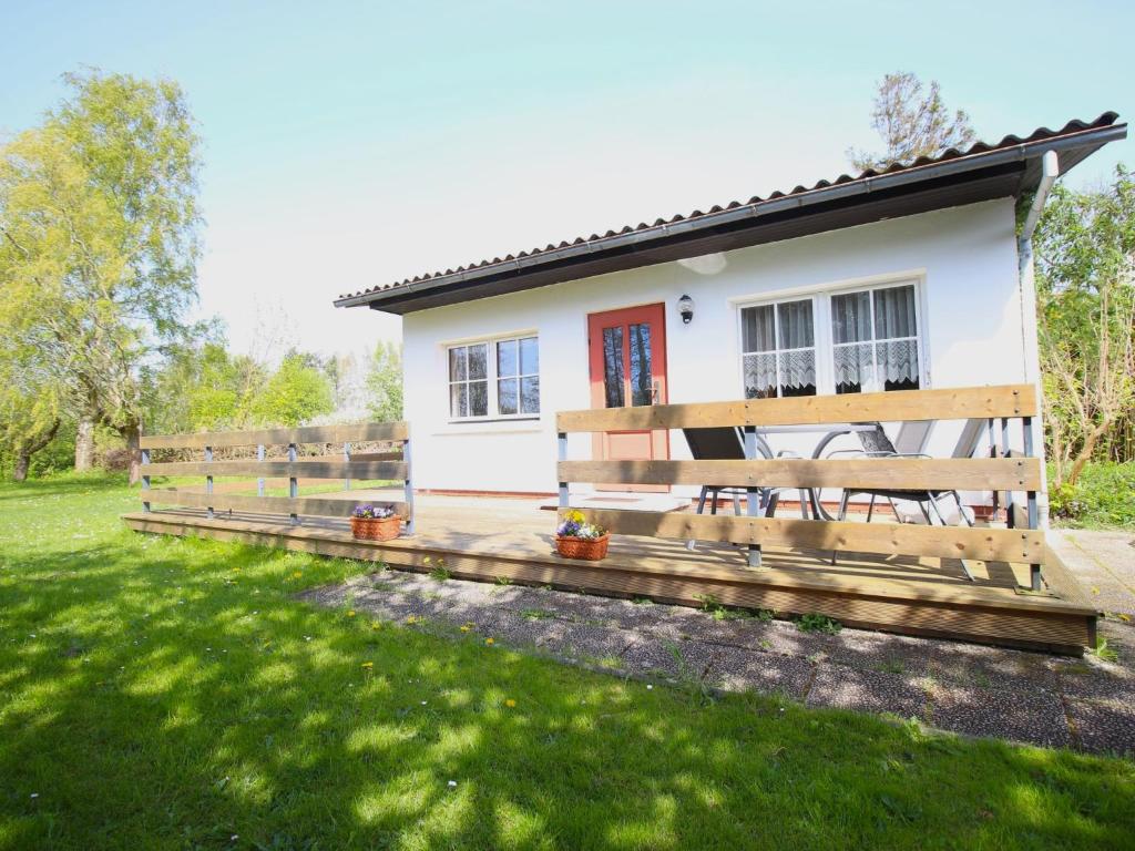 a house with a wooden fence in front of it at Ferienbungalow Schultz in Altenkirchen in Altenkirchen