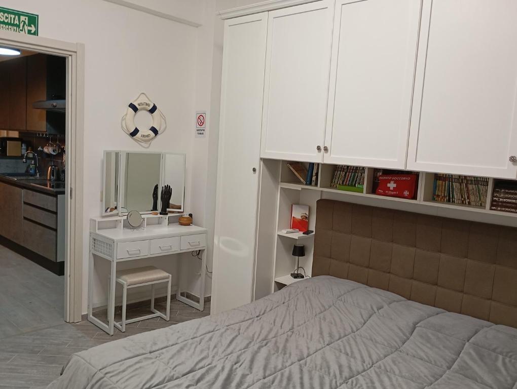 a bedroom with a bed and a desk and a sink at Appartamento 50 mt dal mare in Lido di Ostia