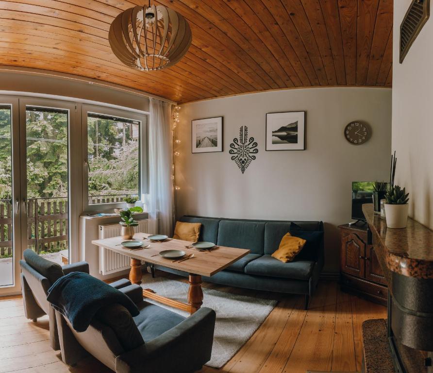 uma sala de estar com um sofá e uma mesa em Leśne zacisze - dom z kominkiem i balią em Jordanów