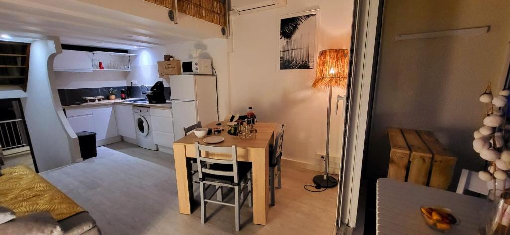 - une petite cuisine avec une table dans une petite pièce dans l'établissement Petit Boudha climatisé Mezzanine rénové parking 400m plage 50m commerces, au Grau-du-Roi