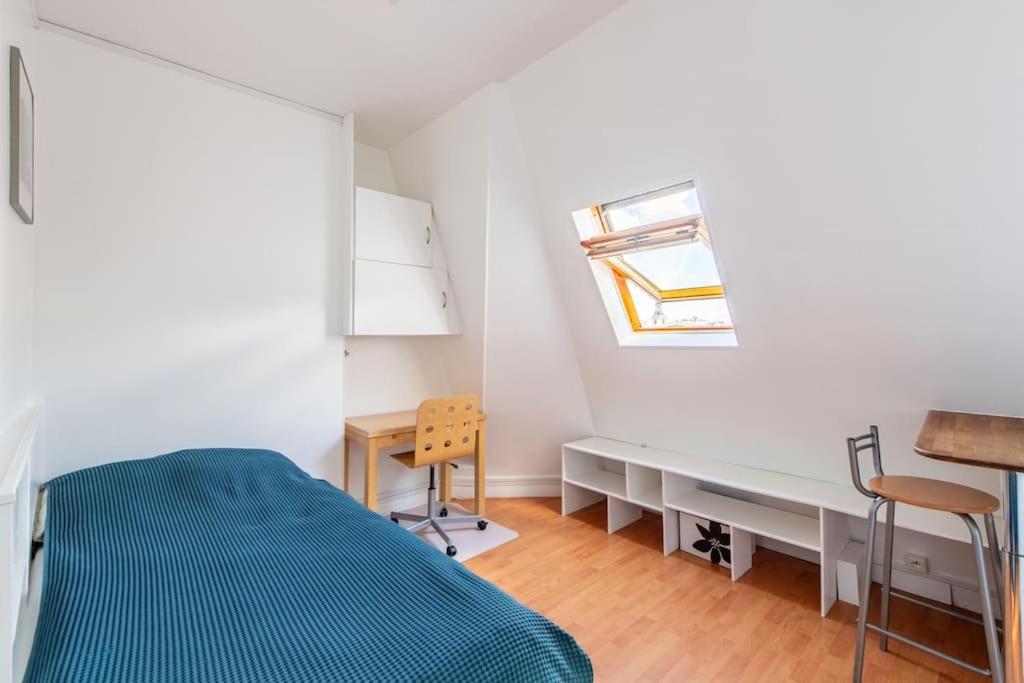 une chambre avec un lit, un bureau et une fenêtre dans l'établissement Paris Centre Studio Close to Major Attractions, à Paris