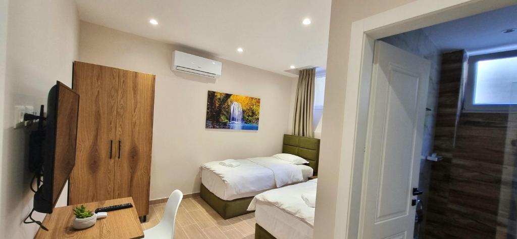 Habitación de hotel con 2 camas, escritorio y 1 dormitorio en Vila Panto, en Tirana