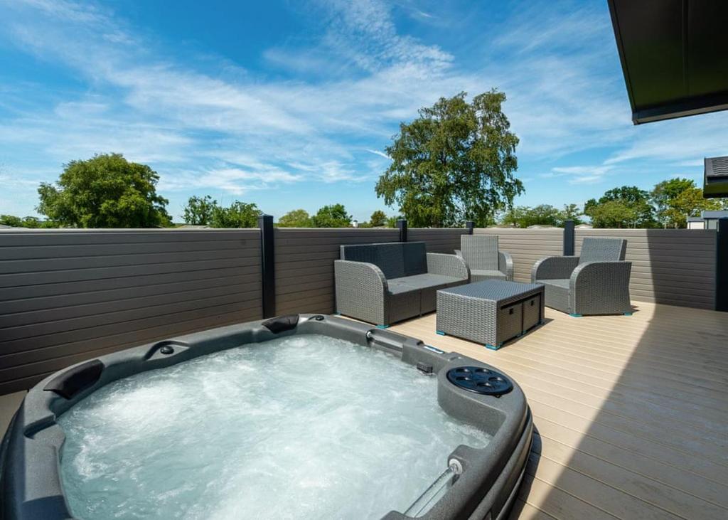 a hot tub on the deck of a house at Green Meadows Country Park in Harker