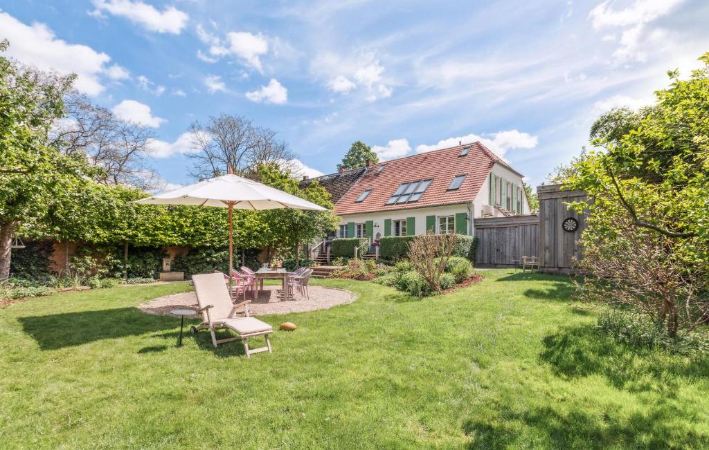a patio with an umbrella and chairs in a yard at Awesome Home In Netzeband With Sauna in Netzeband