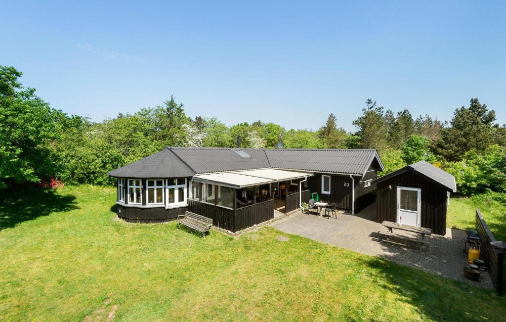 ein großes schwarzes Haus auf einem Grasfeld in der Unterkunft 4 Bedroom Beautiful Home In Skjern in Skjern