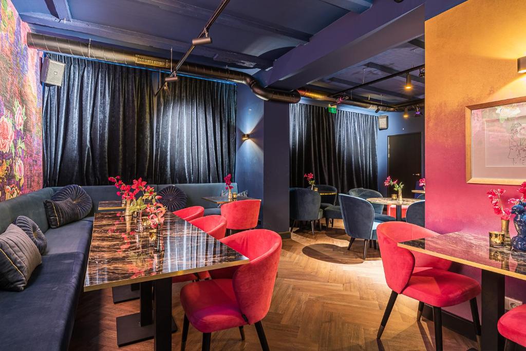 De Bij Middelburg في ميدلبورغ: غرفة طعام مع طاولات وكراسي حمراء