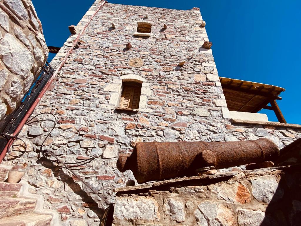 a tall brick tower with a window on a building at Castle Rizaraki in Kokkala