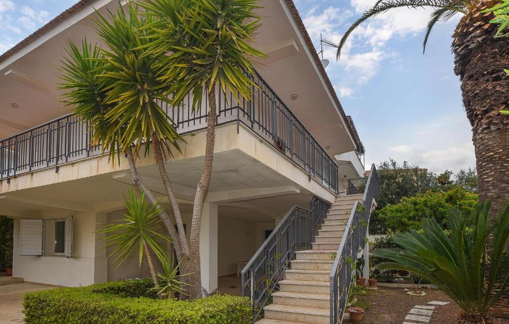 ein Gebäude mit Treppen und einer Palme in der Unterkunft Nice Apartment In Marina Di Modica in Marina di Modica