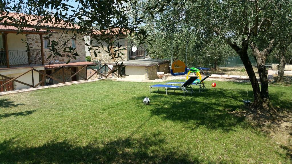 a person sitting on a bench in a yard at Dirindello House Trasimeno in Magione